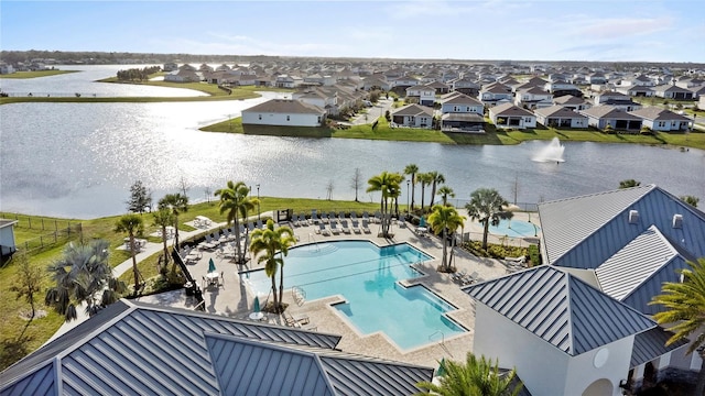 community pool featuring a water view, a residential view, and a patio