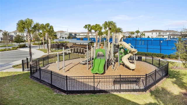 community jungle gym featuring a residential view, fence, and a yard