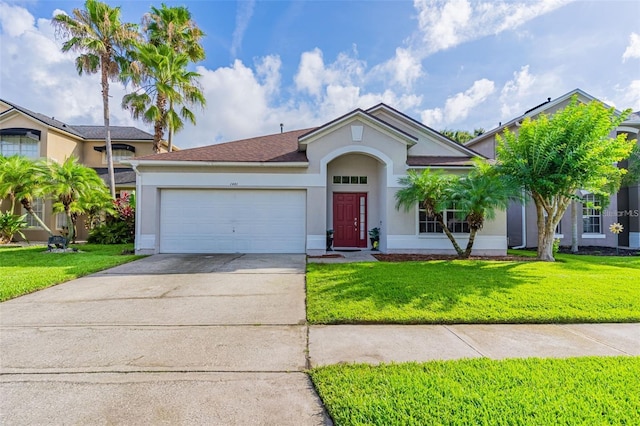 single story home featuring an attached garage, a front lawn, concrete driveway, and stucco siding