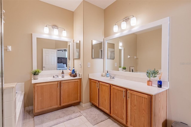 full bath with tiled tub, tile patterned flooring, vanity, and ensuite bathroom