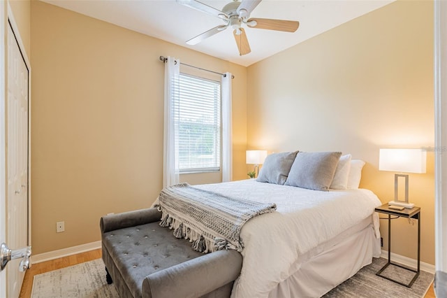 bedroom with ceiling fan, light wood finished floors, and baseboards