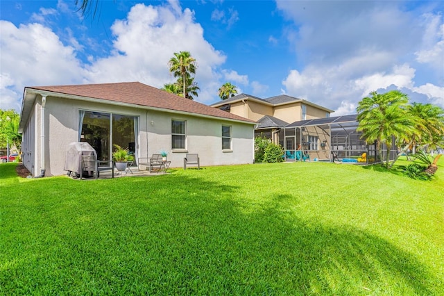 back of house featuring a lanai, a patio area, a yard, and stucco siding