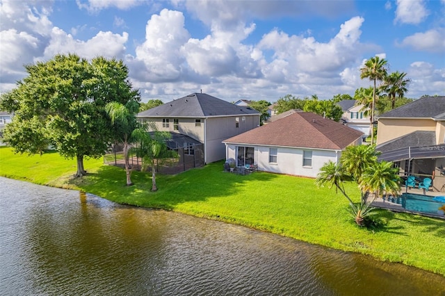 back of house with a yard, stucco siding, a water view, a lanai, and an outdoor pool