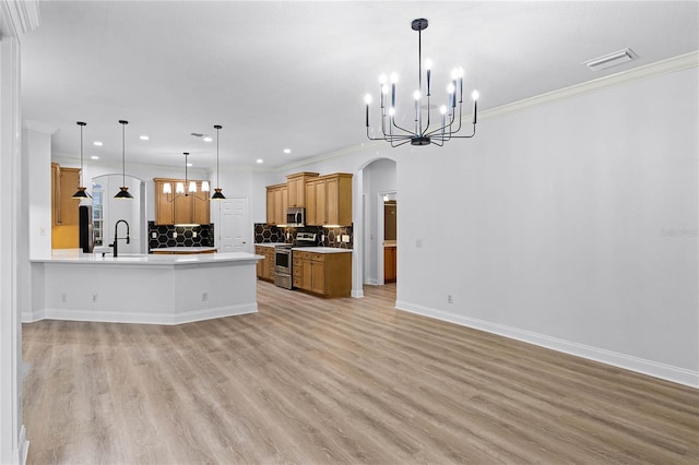 kitchen featuring arched walkways, stainless steel appliances, a sink, and open floor plan