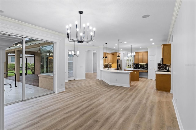 kitchen featuring arched walkways, stainless steel fridge, a sink, and an inviting chandelier