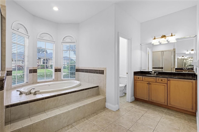 full bath with a garden tub, toilet, vanity, a wealth of natural light, and tile patterned floors