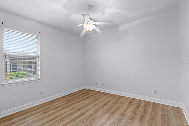 empty room featuring a healthy amount of sunlight, light wood-style floors, and baseboards