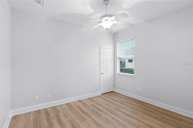 empty room with wood finished floors, a ceiling fan, and baseboards