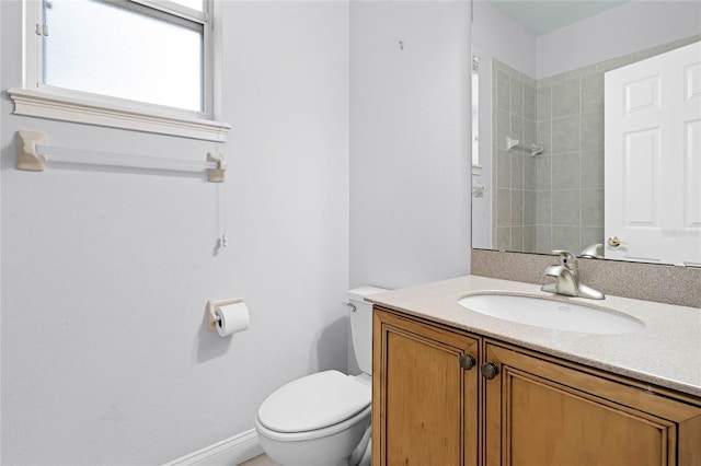 full bath featuring toilet, baseboards, a tile shower, and vanity