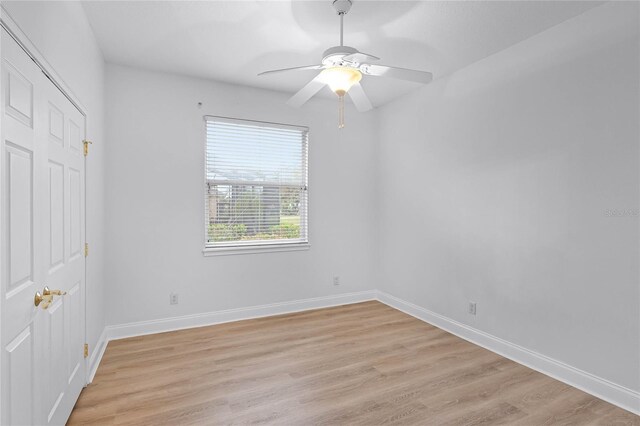 empty room with light wood-style flooring, baseboards, and a ceiling fan