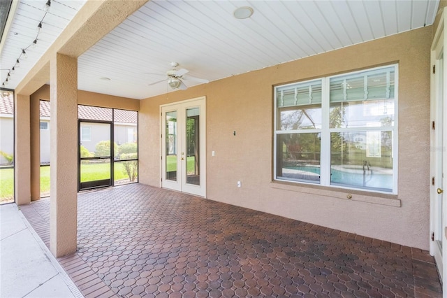 unfurnished sunroom featuring ceiling fan, french doors, and track lighting