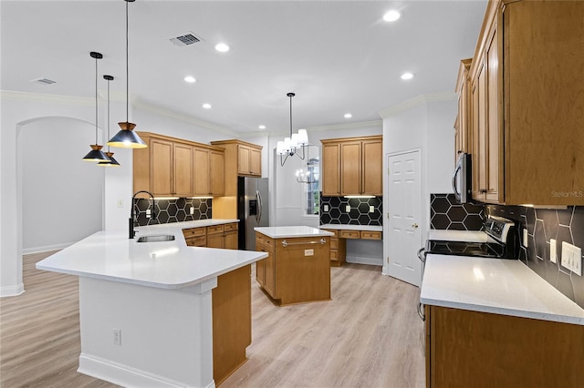 kitchen featuring stainless steel appliances, a kitchen island, a sink, light wood-style floors, and brown cabinets