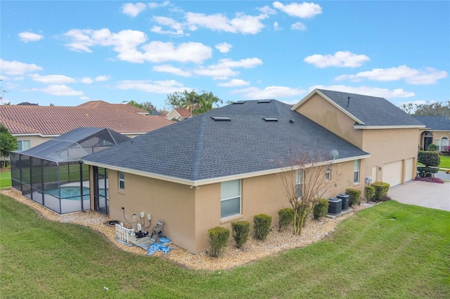 back of property featuring a lanai, a yard, concrete driveway, and stucco siding