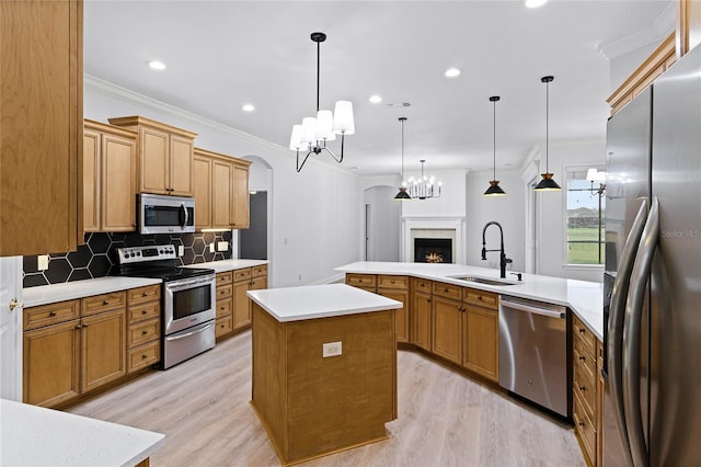 kitchen featuring a center island, stainless steel appliances, tasteful backsplash, ornamental molding, and a sink