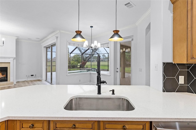 kitchen with a tile fireplace, a sink, and brown cabinets