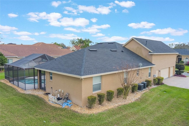 674 Whisper Woods Dr, Lakeland, FL 33813 - rear view of house featuring glass enclosure, concrete driveway, a lawn, and stucco siding