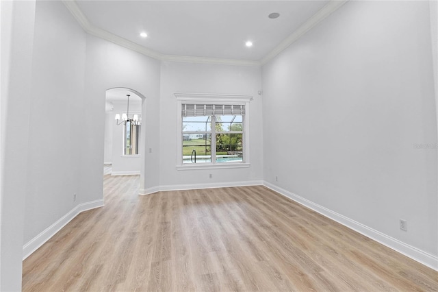 674 Whisper Woods Dr, Lakeland, FL 33813 - empty room featuring crown molding, baseboards, arched walkways, and light wood-type flooring