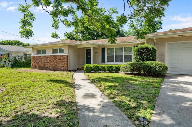 ranch-style house featuring a garage, brick siding, and a front yard