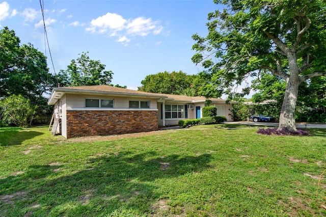 ranch-style home with a garage, driveway, a front lawn, and brick siding