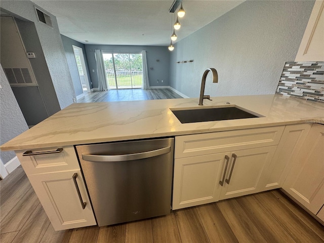 kitchen featuring light stone counters, dark wood-style flooring, white cabinets, a sink, and dishwasher