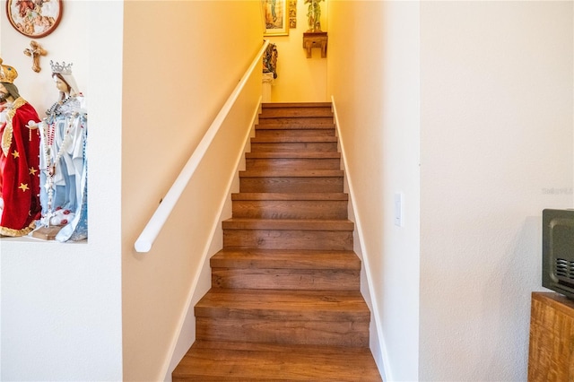 stairs featuring wood finished floors and baseboards