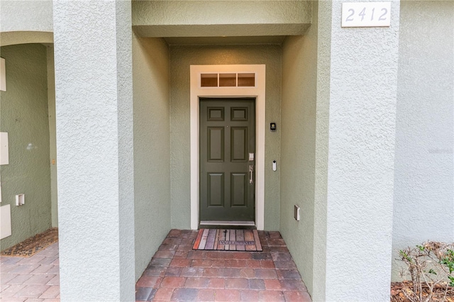 entrance to property featuring stucco siding