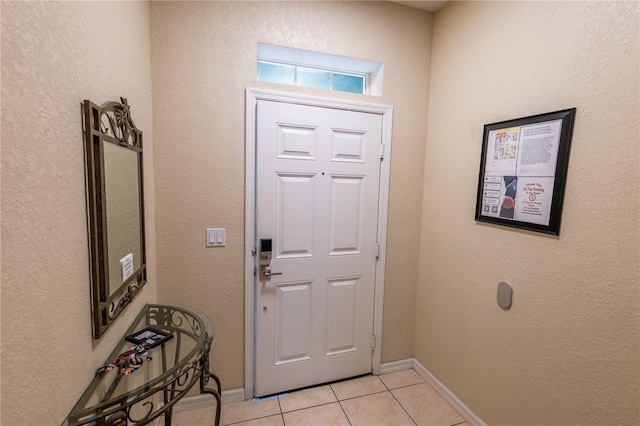 foyer with light tile patterned flooring and baseboards
