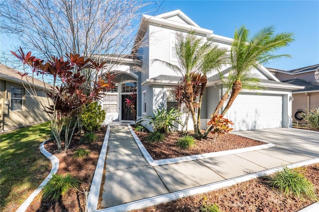 view of front of property with concrete driveway, an attached garage, and stucco siding