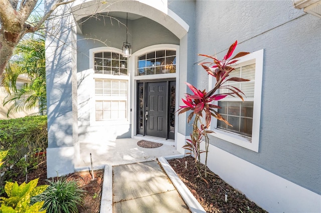 view of exterior entry featuring stucco siding