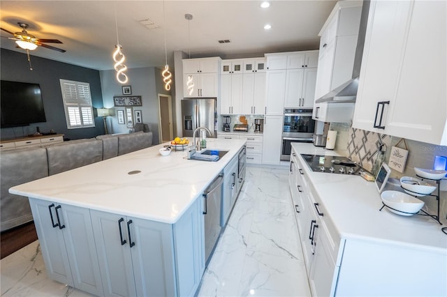 kitchen featuring stainless steel appliances, marble finish floor, a sink, and open floor plan