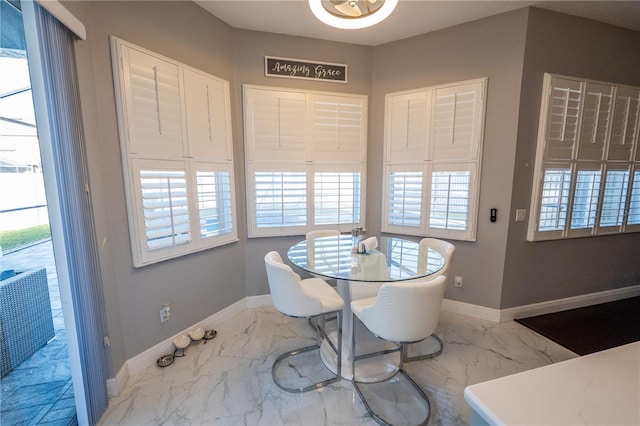 dining room featuring marble finish floor and baseboards