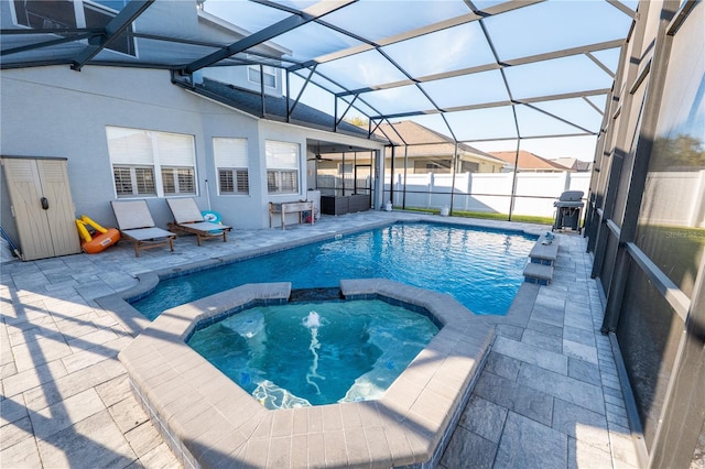 view of pool with glass enclosure, a pool with connected hot tub, a patio area, and fence