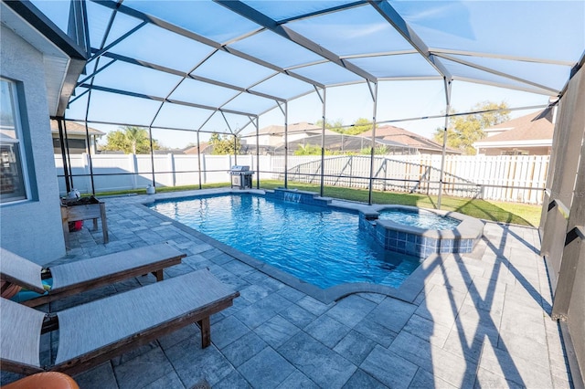 view of pool with glass enclosure, a patio area, a fenced backyard, and a pool with connected hot tub