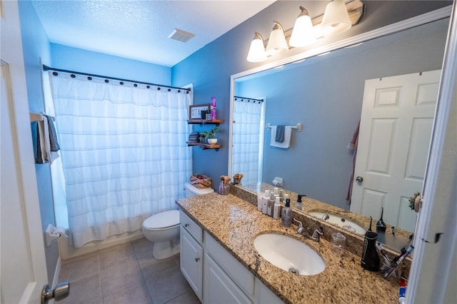 bathroom featuring a textured ceiling, toilet, vanity, visible vents, and tile patterned floors