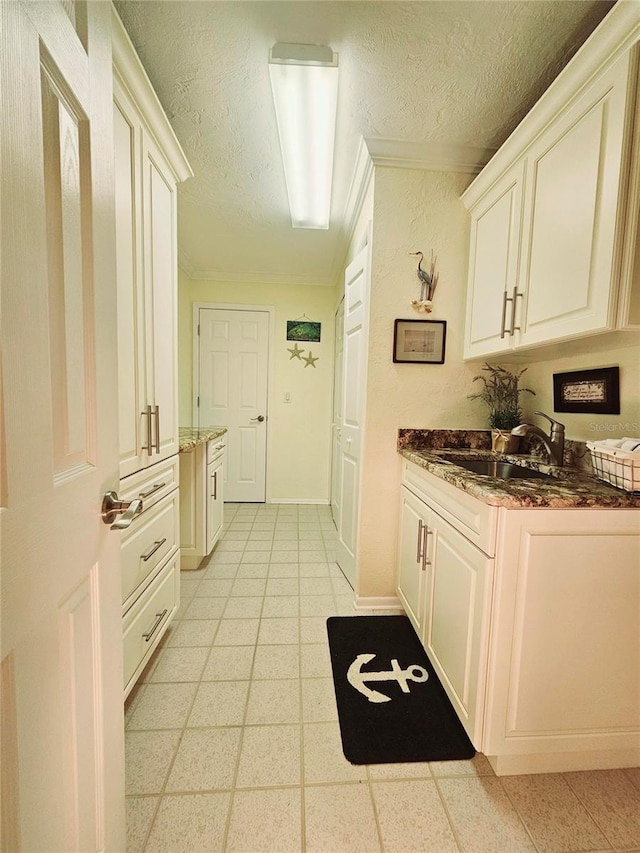 1706 S Lakeside Ct, Venice, FL 34293 - kitchen with a sink, light floors, a textured ceiling, dark stone countertops, and white cabinets