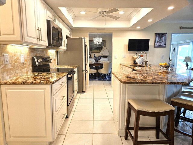 1706 S Lakeside Ct, Venice, FL 34293 - kitchen featuring a sink, a kitchen bar, appliances with stainless steel finishes, decorative backsplash, and ornamental molding