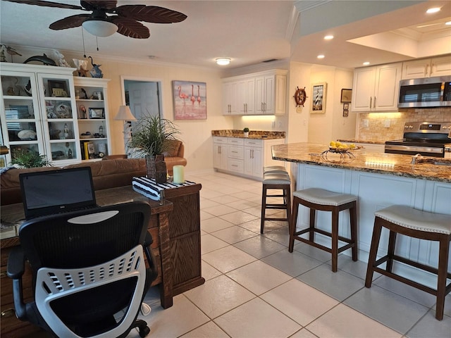 1706 S Lakeside Ct, Venice, FL 34293 - kitchen featuring a kitchen bar, ornamental molding, stainless steel appliances, light tile patterned flooring, and stone counters