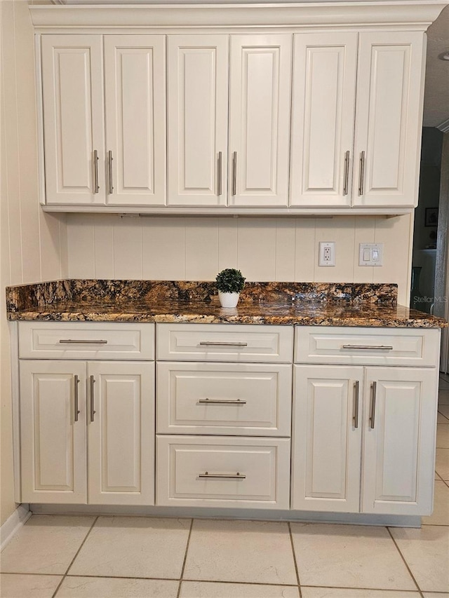 1706 S Lakeside Ct, Venice, FL 34293 - kitchen featuring white cabinets, light tile patterned floors, and dark stone counters