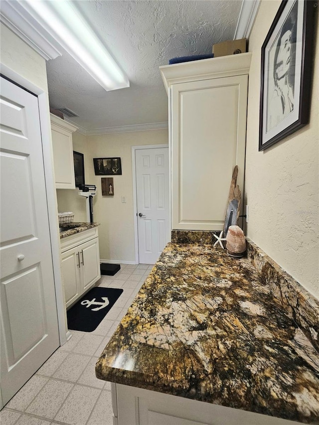1706 S Lakeside Ct, Venice, FL 34293 - kitchen with white cabinetry, crown molding, baseboards, and a textured ceiling