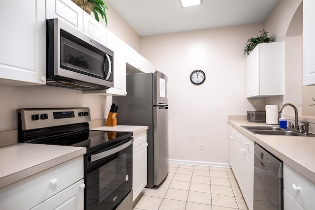 kitchen featuring light countertops, appliances with stainless steel finishes, a sink, and white cabinetry