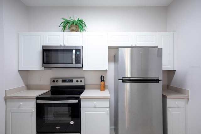 kitchen with light countertops, appliances with stainless steel finishes, and white cabinetry