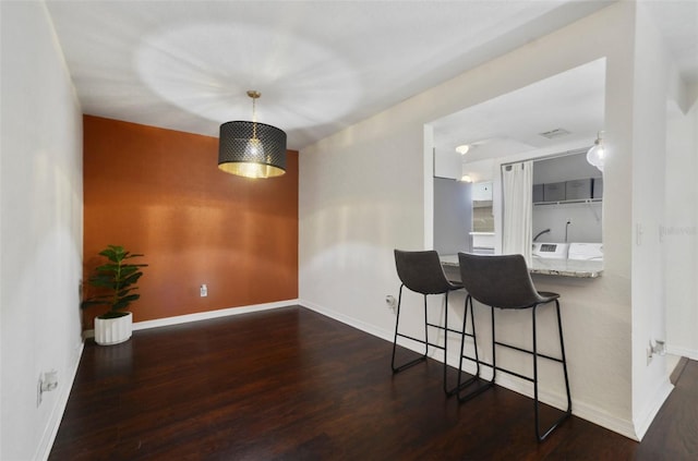 4300 Hector Ct Unit 7, Orlando, FL 32822 - kitchen with baseboards, a breakfast bar, wood finished floors, and decorative light fixtures