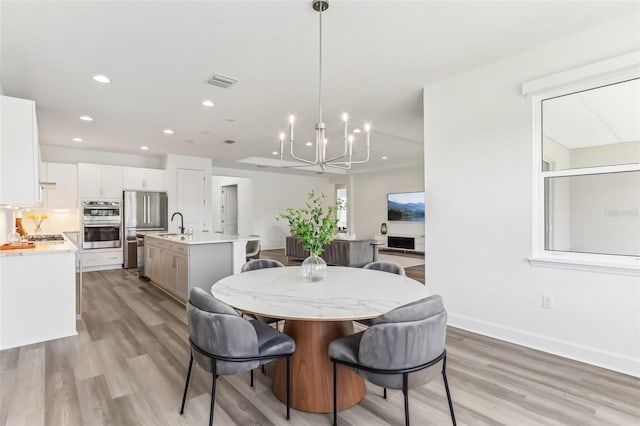 dining space with light wood-style flooring, visible vents, baseboards, and recessed lighting