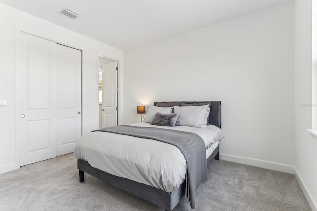 bedroom with a closet, carpet, visible vents, and baseboards