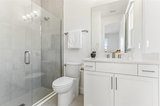 bathroom featuring a shower stall, toilet, and vanity