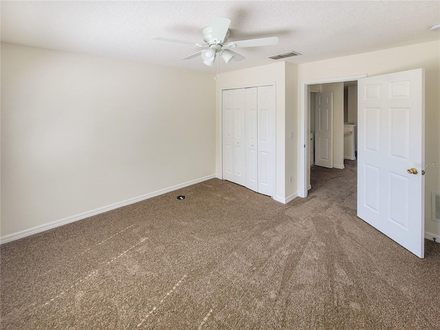 unfurnished bedroom featuring a textured ceiling, carpet flooring, visible vents, baseboards, and a closet