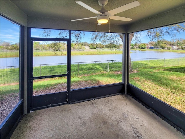 unfurnished sunroom with ceiling fan, a water view, and a wealth of natural light