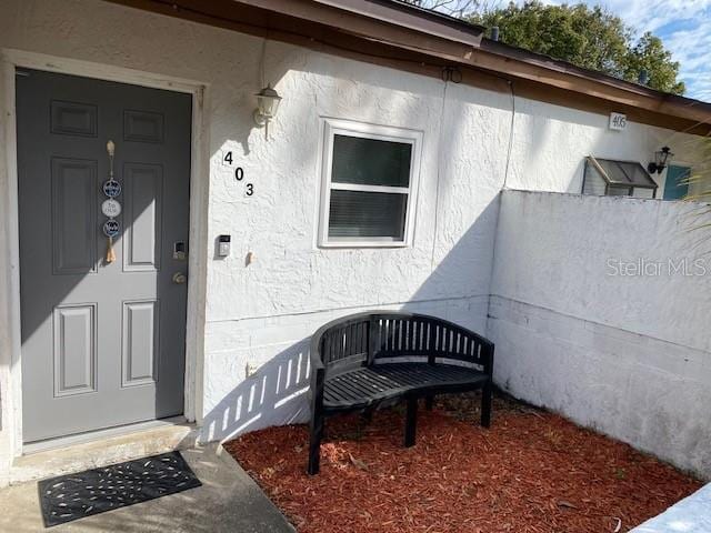 property entrance with stucco siding