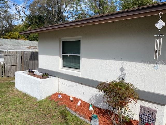 view of side of property featuring fence and stucco siding