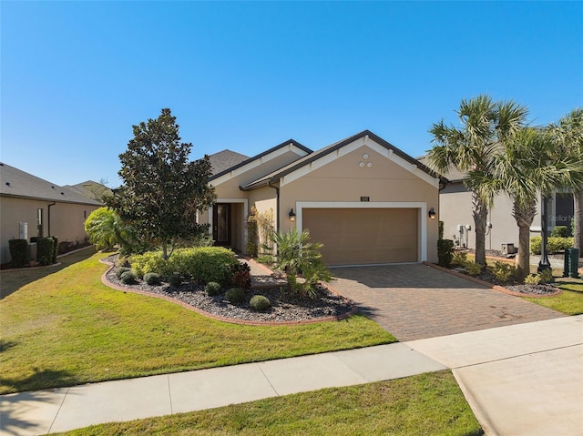 view of front of property featuring a garage, a front lawn, decorative driveway, and stucco siding